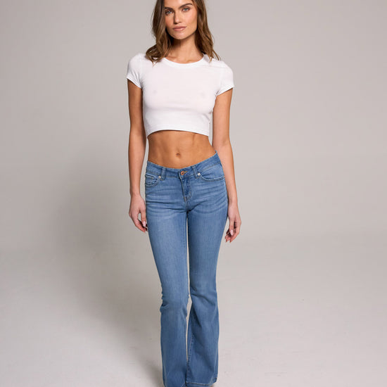 Stylish model showcasing Low Rise Bootcut Jeans - Medium Blue Black, made from a comfortable cotton blend.